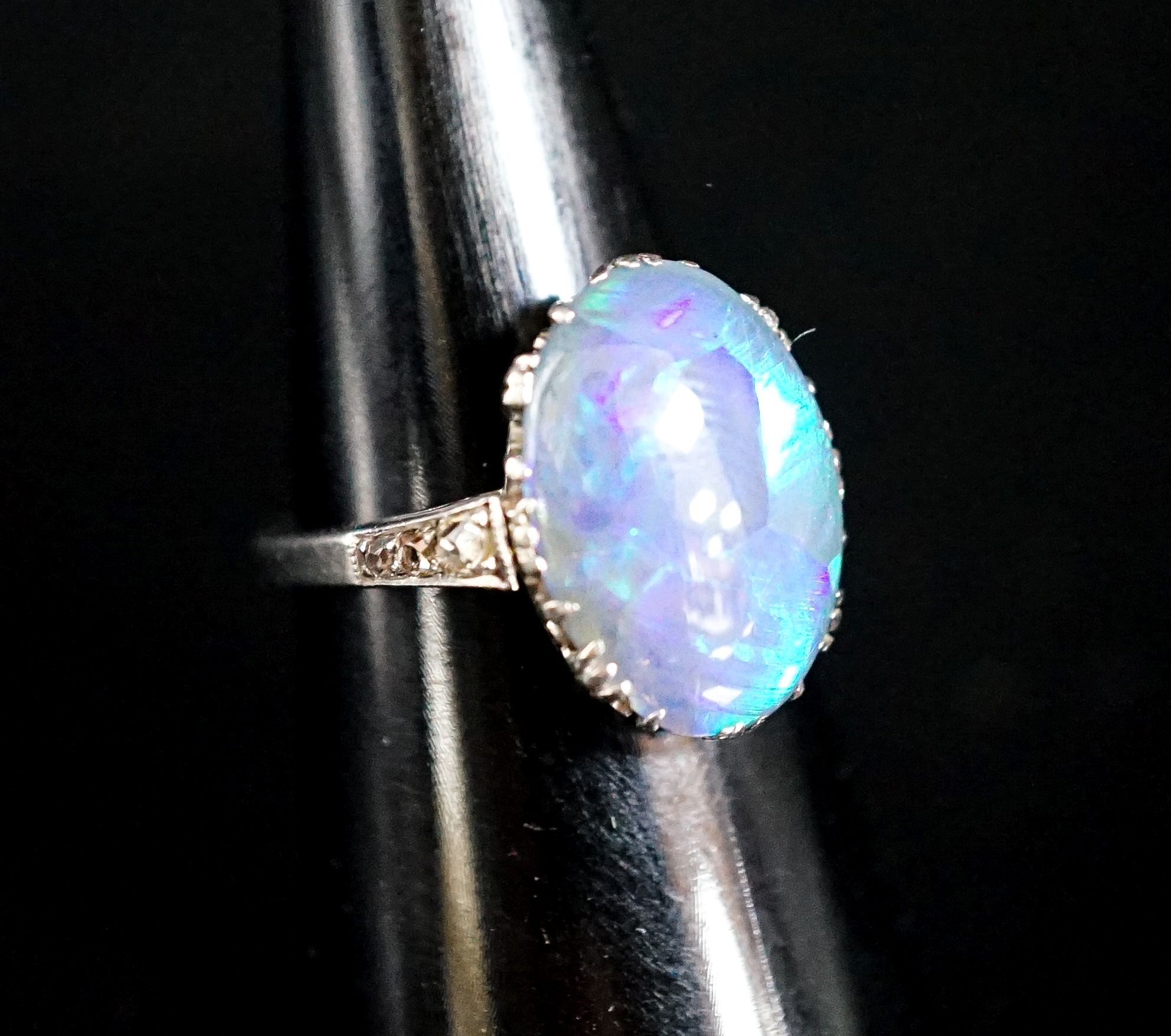 A 1920's white metal and black opal set oval dress rig, with diamond set shoulders, size N, gross 3.8 grams.